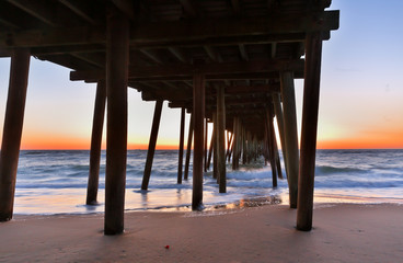 Fototapeta premium Fishing Pier at Sunrise at Virginia Beach, Virginia, USA. Virginia Beach, a coastal city in southeastern Virginia, lies where the Chesapeake Bay meets the Atlantic Ocean.