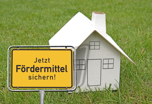 Ortsschild, Kartonhaus &bdquo;Jetzt F&ouml;rdermittel sichern!&ldquo;