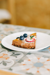 delicious slice of chocolate cake with berries on a white plate in a restaurant