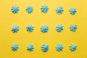 Sweet blue meringues on yellow background