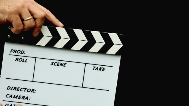Footage of a person using a clapper board isolated on a black background...