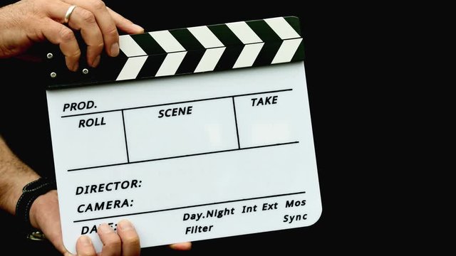 Footage of a person using a clapper board isolated on a black background