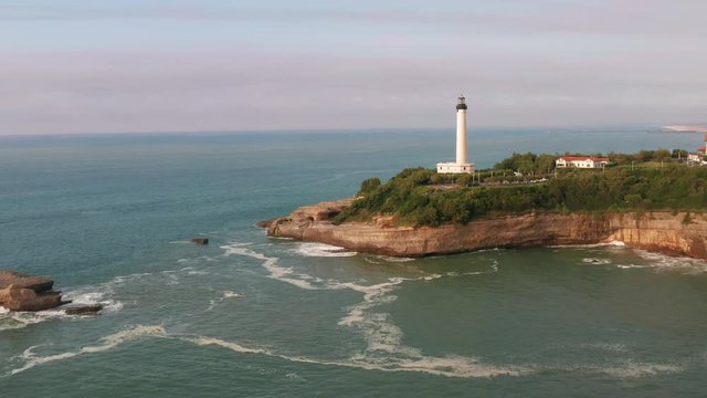 Phare de Biarritz. Drone flight pulling back from lighthouse. Atlantic Ocean, Cape Hainsart, Biarritz, France.