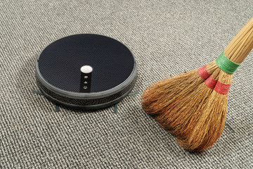 robot vacuum cleaner and old broom