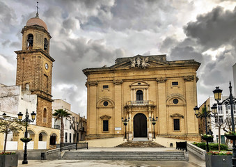 View of Major church and historic clock tower in old town Chiclana de la Frontera, Spain.