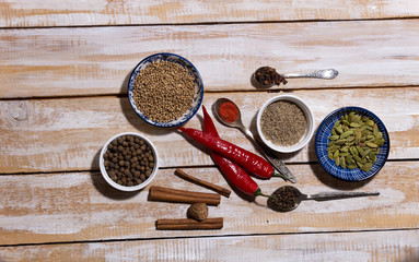 mix of spices baharat in bowls ans spoons on the wooden  background with copy space