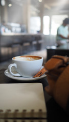 Selective focus cup of hot coffee on table in coffee shop with blurred backgrounds