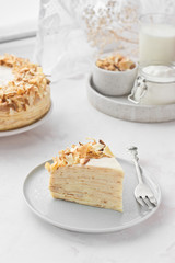 A piece of Napoleon crepe cake with custard. Maslenitsa (Shrovetide) or Birthday meal on white background.