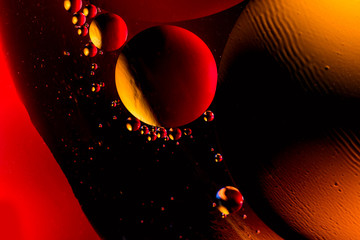 Macro shot of oil bubbles with water on colorful background. Space and universe planets styled...