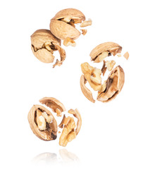 Group of crushed walnuts in the air close-up on a white background