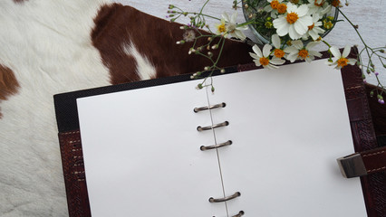 Open blank book page with leather cover on horse fur on white wooden table, selective focus for business and education   concepts backgrounds