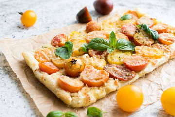 Vegetable puff pastry tart with colorful tomatoes