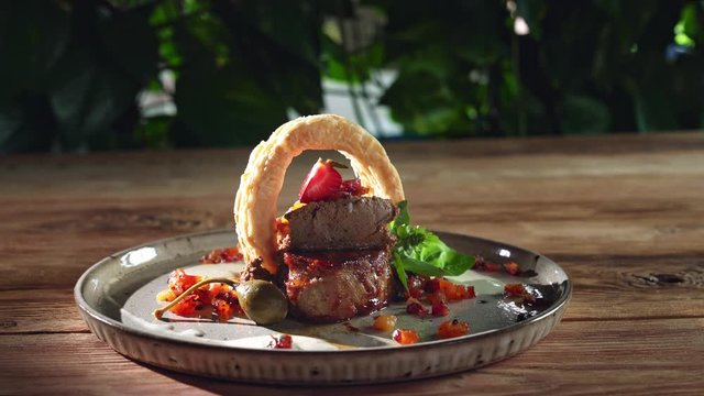 Meat served with berries and breader ring.