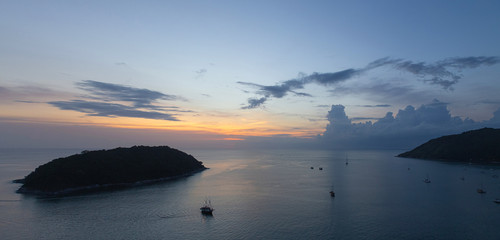 stunning sunset above Man island in front of Promthep cape and wind turbine viewpoint. Phuket, Thailand