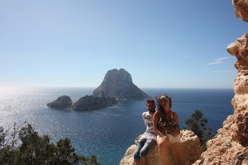young caucasian couple in love on a rock of a steep cliff in the rocky desert of cala d'hort in...