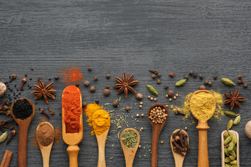 Various aromatic colorful spices and herbs in wooden spoons and scoops.  Ingredients for cooking.  Ayurvedic treatments. Top view.