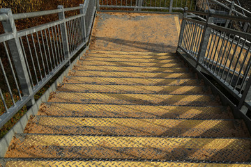 Metal stairs with steps sprinkled with sand