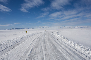 Snow everywhere as far as the eye can see. A lonely road somewhere on iceland.