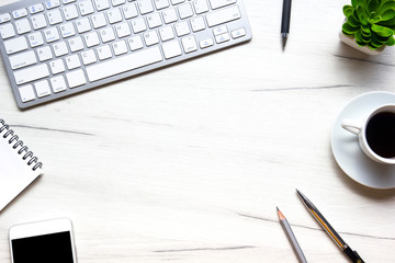 White desk office with laptop, smartphone and other work supplies with cup of coffee. Top view with copy space for input the text. Designer workspace on desk table essential elements on flat lay