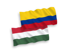 National vector fabric wave flags of Colombia and Hungary isolated on white background. 1 to 2 proportion.