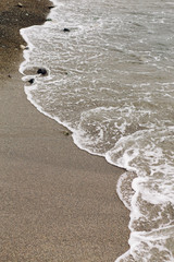 the sea wave arrives on the sandy shore . beautiful natural background