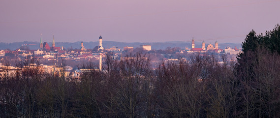 Panorama image of Augsburg skyline during sunset with mountains in the background
