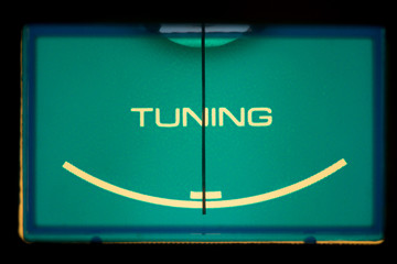 Classic radio tuner panel close-up. Black background