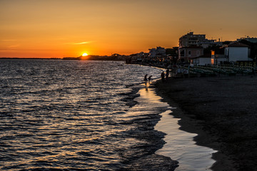 beach at sunset with orange sky in Follonica