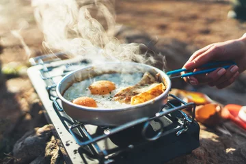 Crédence de cuisine en verre imprimé Camping personne cuisinant des œufs au plat dans la nature camping en plein air, cuisinière prépare un pique-nique pour le petit-déjeuner brouillé sur une cuisinière à gaz en métal, loisirs touristiques à l& 39 extérieur  mode de vie camping