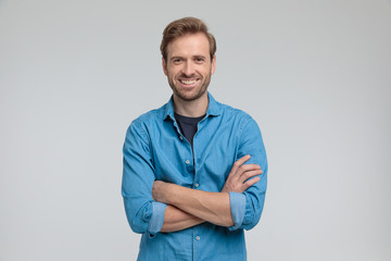 enthusiastic young casual man crossing arms and smiling