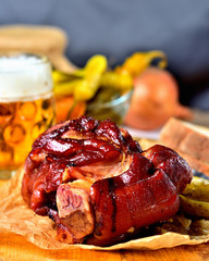 Roasted pork knuckle with beer, mustard, pickles and goat horns pepper vegetable.. Vertical photo. Still life.