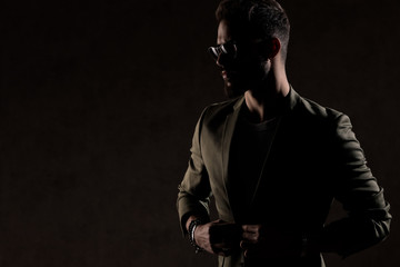 cool unshaved guy looking to side and posing in a fashion light
