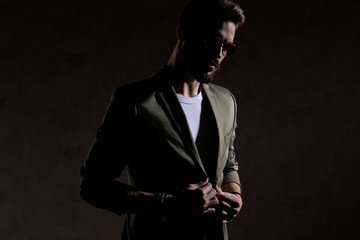 sexy cool young model adjusting coat in a fashion light