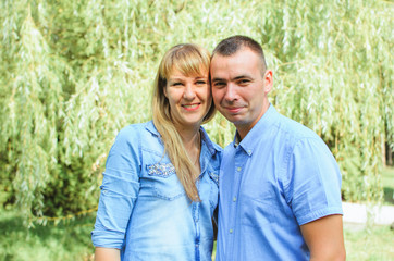 Obraz premium family shot in the park, summer day. .a guy with a girl dressed in a denim suit. very happy, cheerful and in love