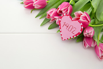 Vlentine's Day heart and a bouquet of beautiful tulips on wooden background.