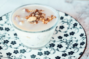 Albanian yogurt dessert with honey and walnuts nuts over white plate
