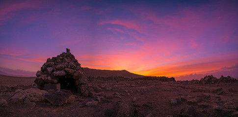 red sunset in small stone house