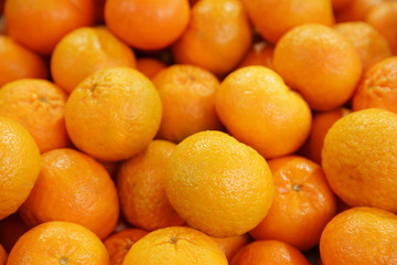 pile of fresh mandarines or tangerines on the market. Tropical citrus concept.