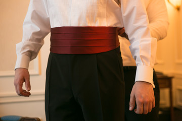 The Elegant man dresses red cummerbund in his wedding day