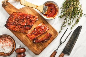 Delicious barbecued ribs seasoned with a spicy basting sauce and served on chopping board.