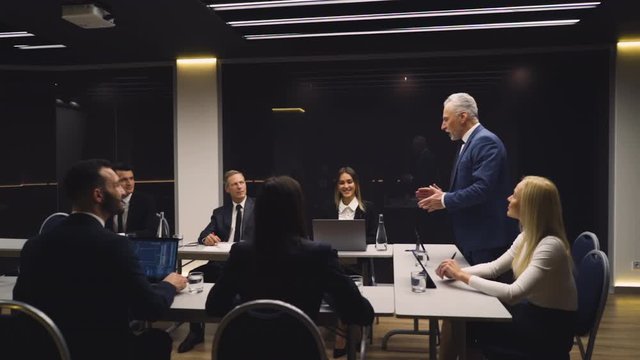 The businessman and his team sitting at the table and discuss