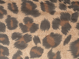 Abstract background in the form of dark brown black spots on a light brown background. Like a leopard paint. Close up