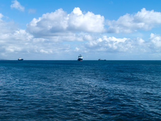 Blue sea and sky with fluffy clouds
