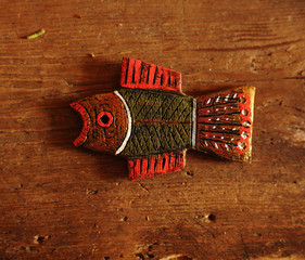 hands of a master hold handmade wooden painted brooches,figures of wooden birds
