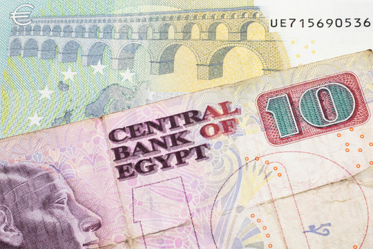 A ten Egyptian pound bill with a blue and green five euro note from France close up in macro