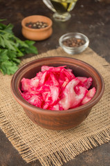 Coleslaw with beets in a clay bowl. Fermented foods. Homemade food. Sour food. Pickled vegetables. Vegetarian vegan food.