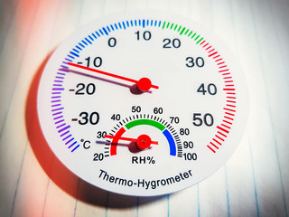 An analog hygrometer with a scale and an arrow for measuring temperature and humidity at home