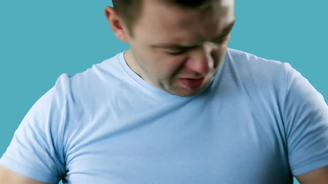Young man having problem sweat under armpit. Young man sniffing his armpit, something stinks very bad. Bad smells concept.