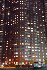 Night panorama of light in windows of multistory building. Life in big city