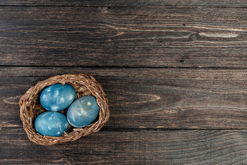Fototapeta na wymiar Dark green easter egg in basket on white background